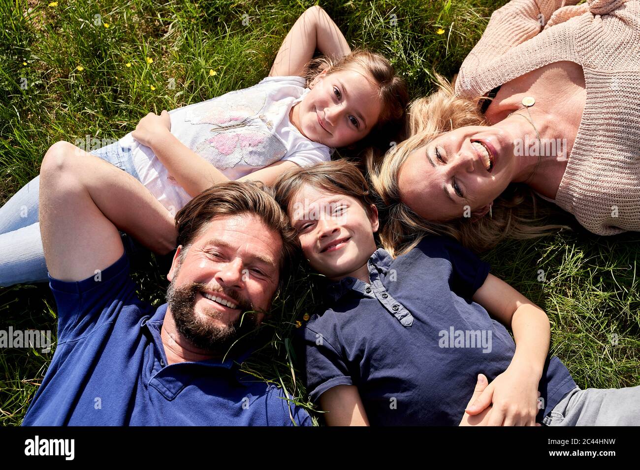 Happy family lying on grass hi-res stock photography and images - Alamy
