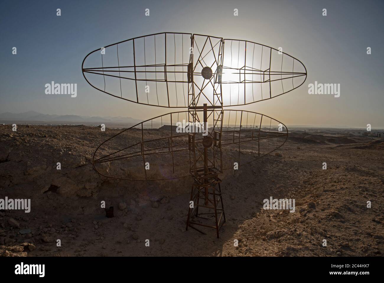 Closeup of old derelict military radar aerial abandoned in remote african desert landscape with sunset Stock Photo