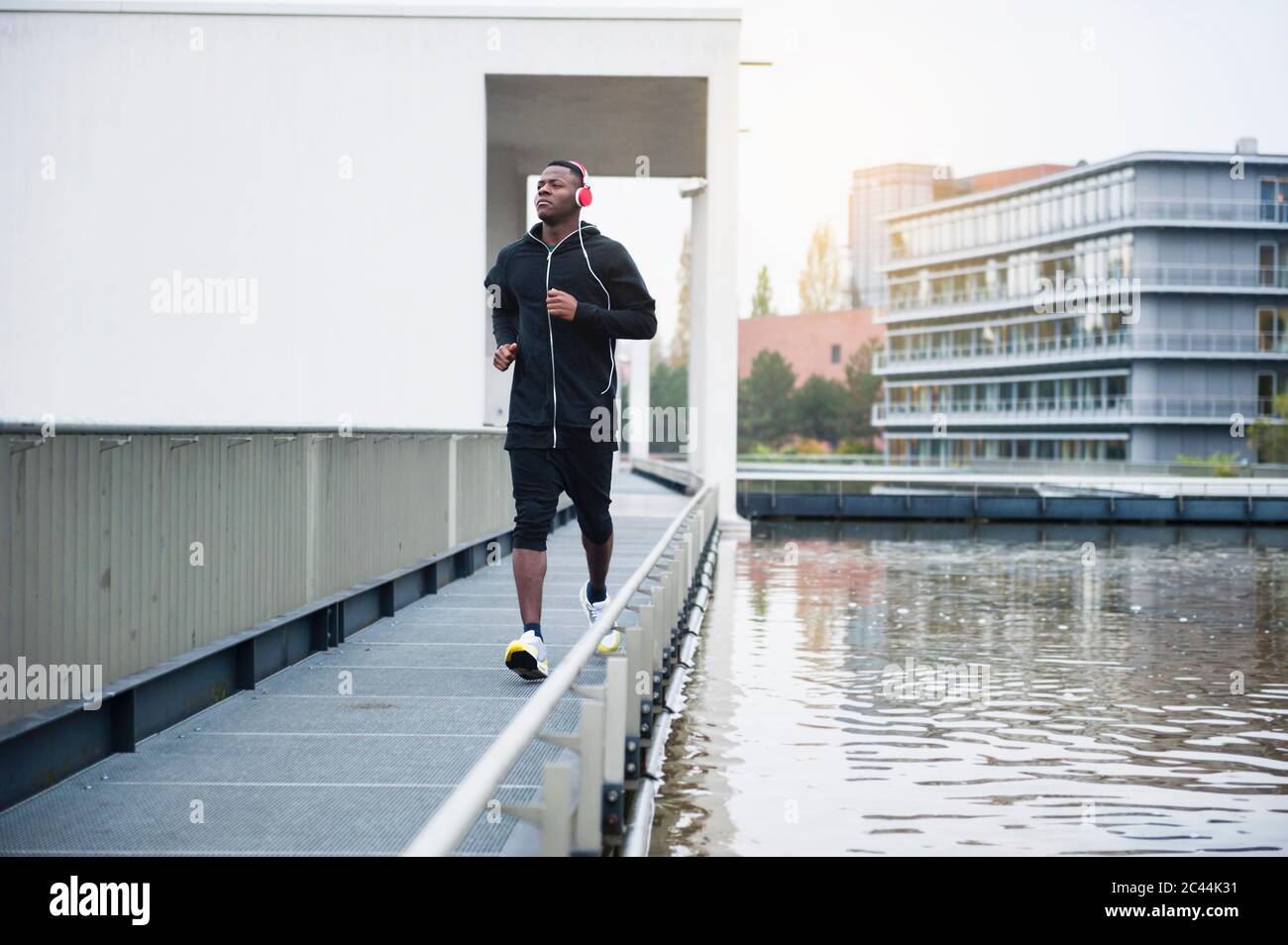 Young man with headphones jogging in the city Stock Photo