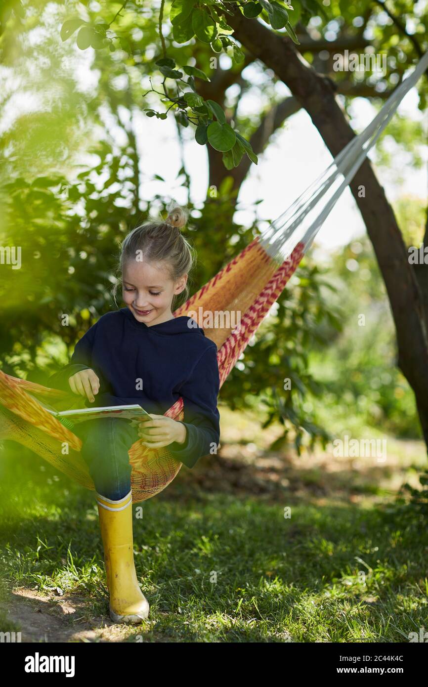 Girl in hammock reading a book Stock Photo - Alamy