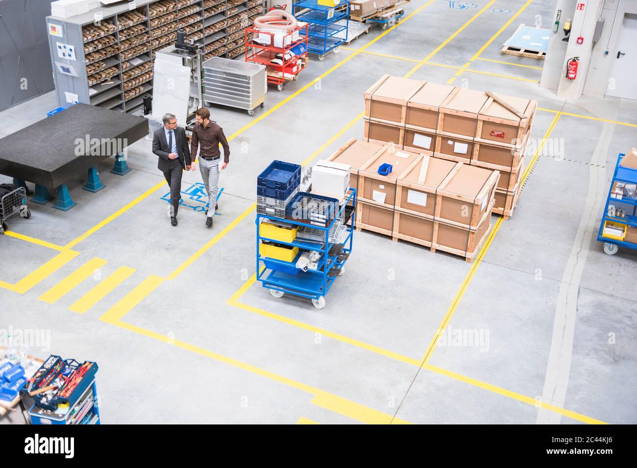 Two businessmen walking and talking on factory shop floor Stock Photo ...