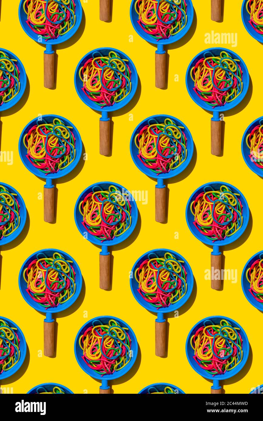Pattern of toy frying pans with colorful pasta Stock Photo