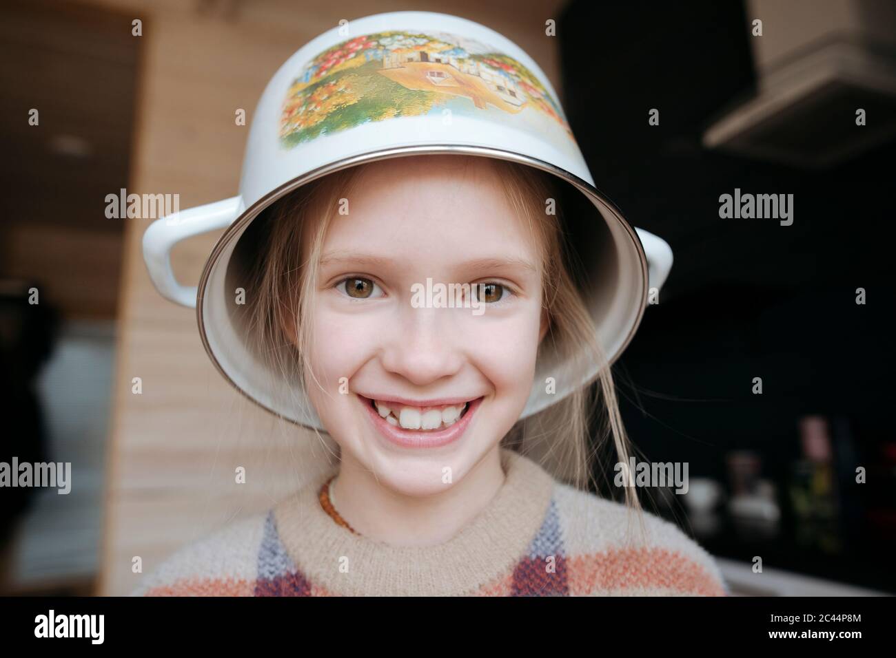 Portrait of playful girl with cooking pot o her head Stock Photo Alamy