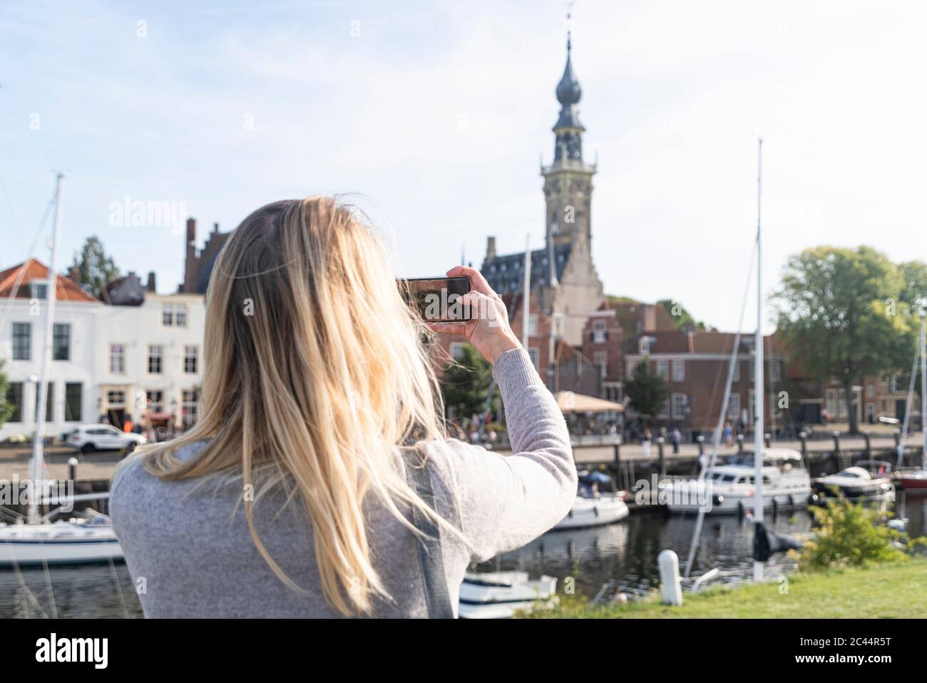 Netherlands, Zeeland, Veere, woman taking photo of old town Stock Photo