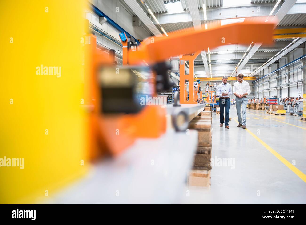 Two men walking and talking on factory shop floor Stock Photo - Alamy