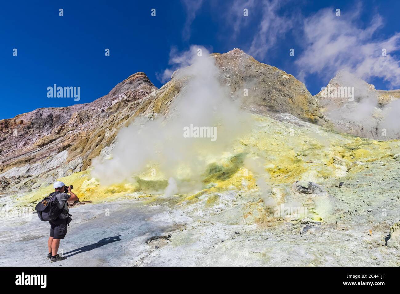New Zealand, North Island, Whakatane, Male hiker photographing active fumarole at White Island (Whakaari) Stock Photo