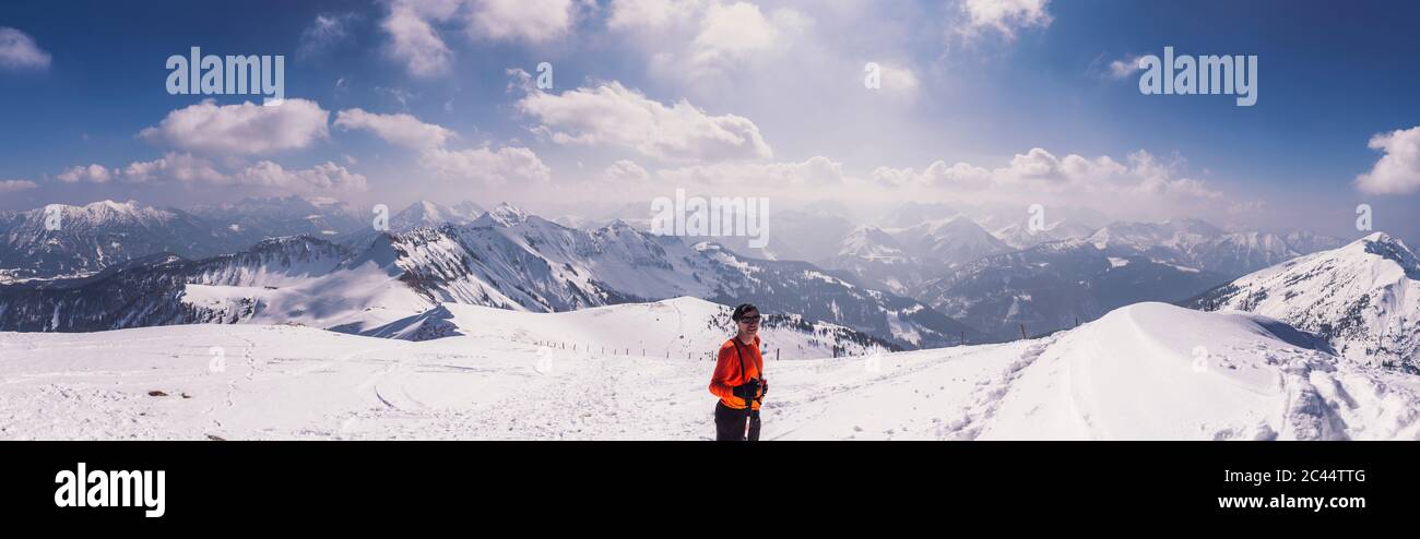 Happy male hiker standing on snow covered mountain during ski holiday at Achenkirch, Tyrol, Austria Stock Photo