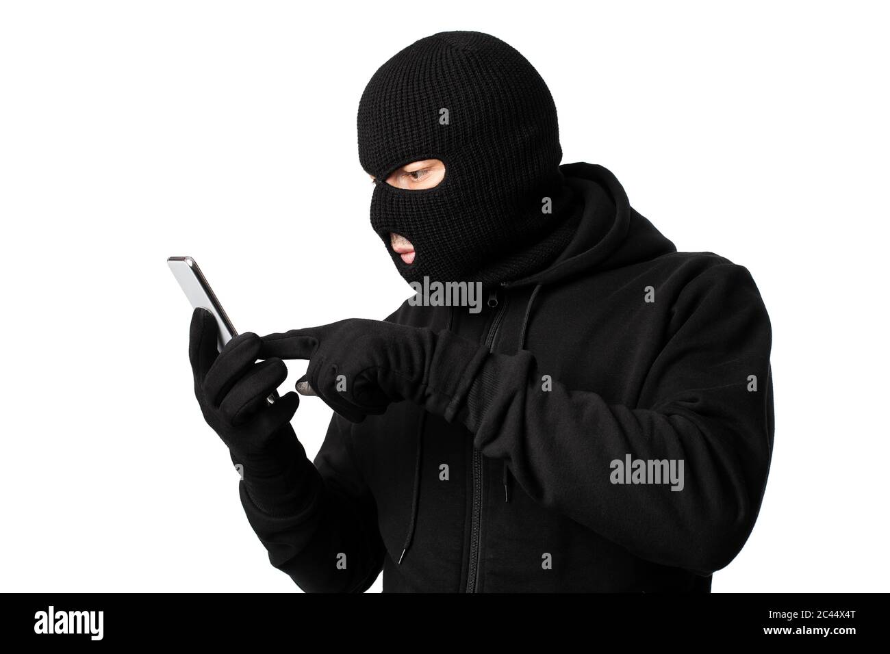 Masked villain touching a smart phone screen Stock Photo