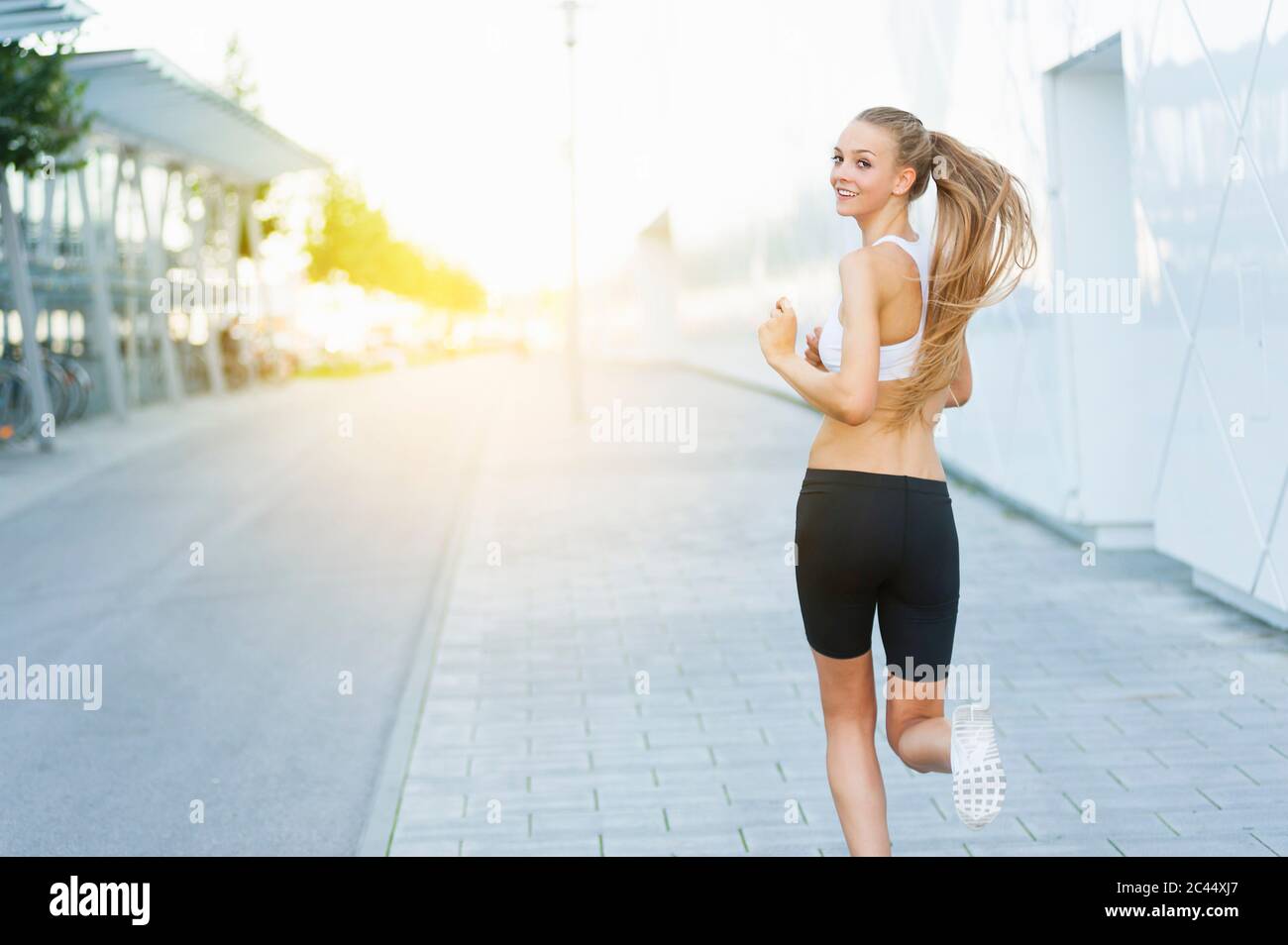 Woman jogging in the city and turning Stock Photo