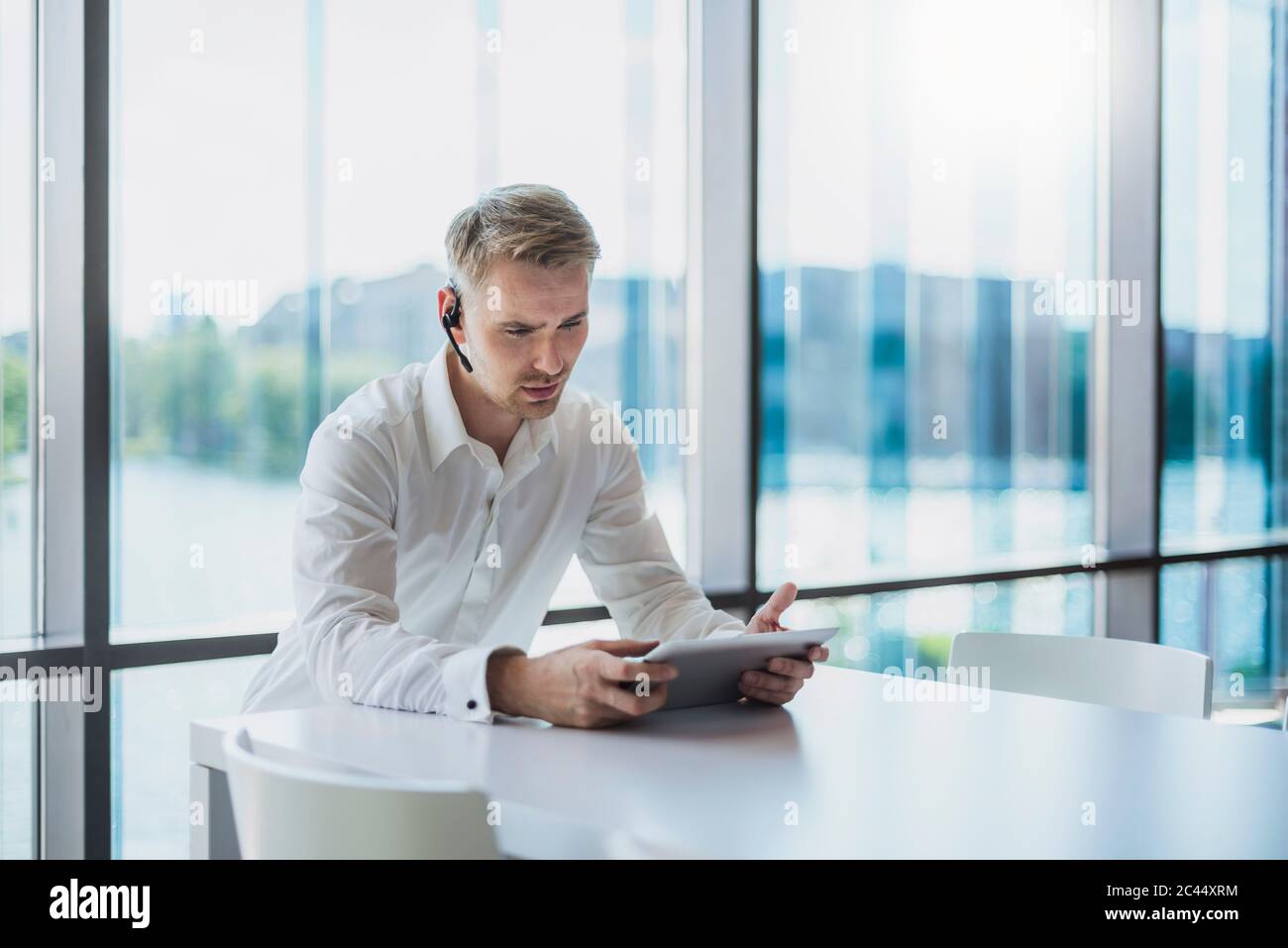 Businessman doing a call with a headset, using digital tablet Stock Photo
