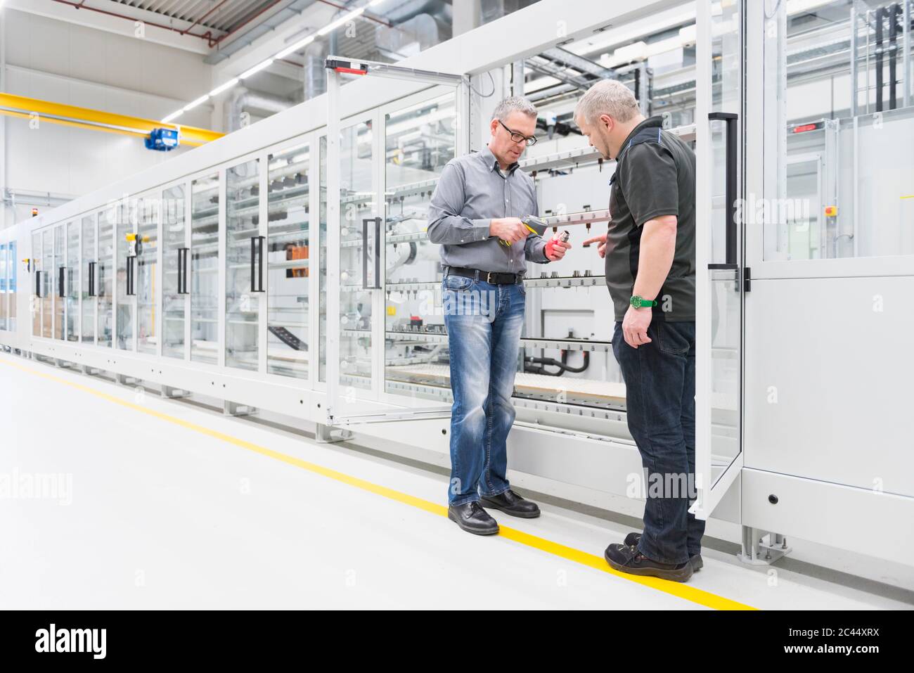 Two men talking in a factory Stock Photo