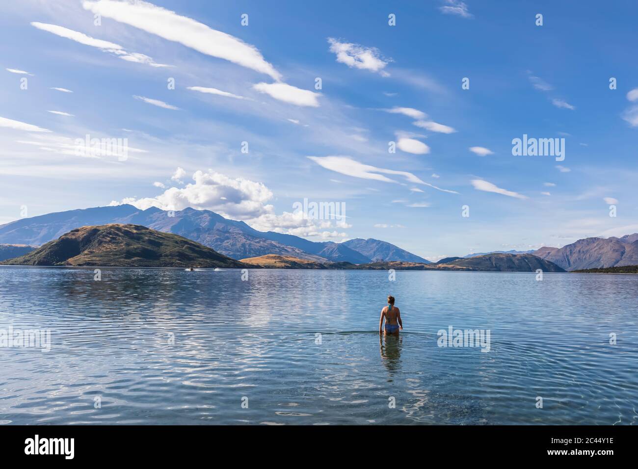 New Zealand, Queenstown-Lakes District, Glendhu Bay, Female tourist standing waist deep in Lake Wanaka Stock Photo