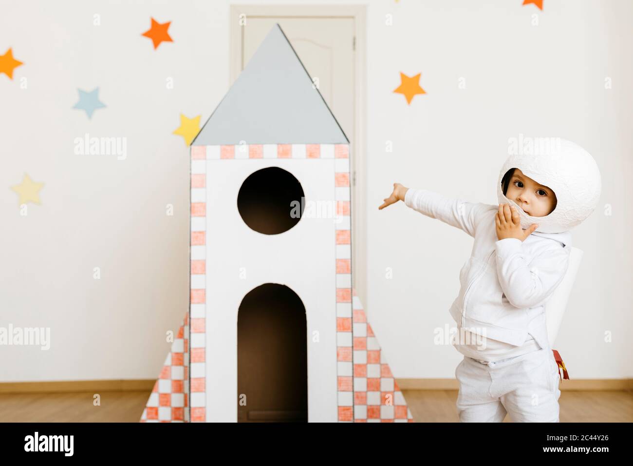 Girl wearing costume and playing astronaut at rocket Stock Photo