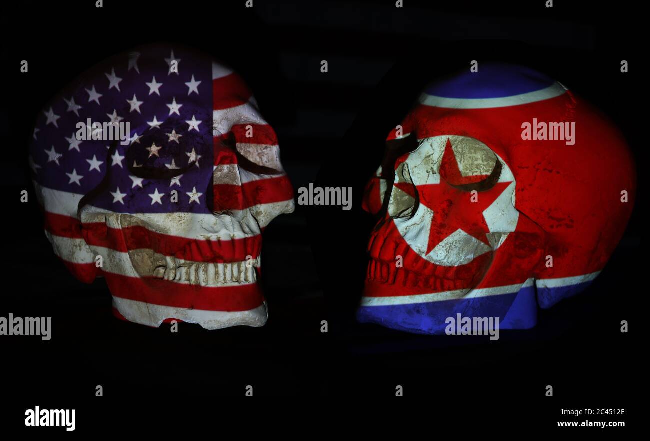 American or US and Nth Korean flags projected over two realistic looking white skulls. Isolated against a plain black background. Stock Photo