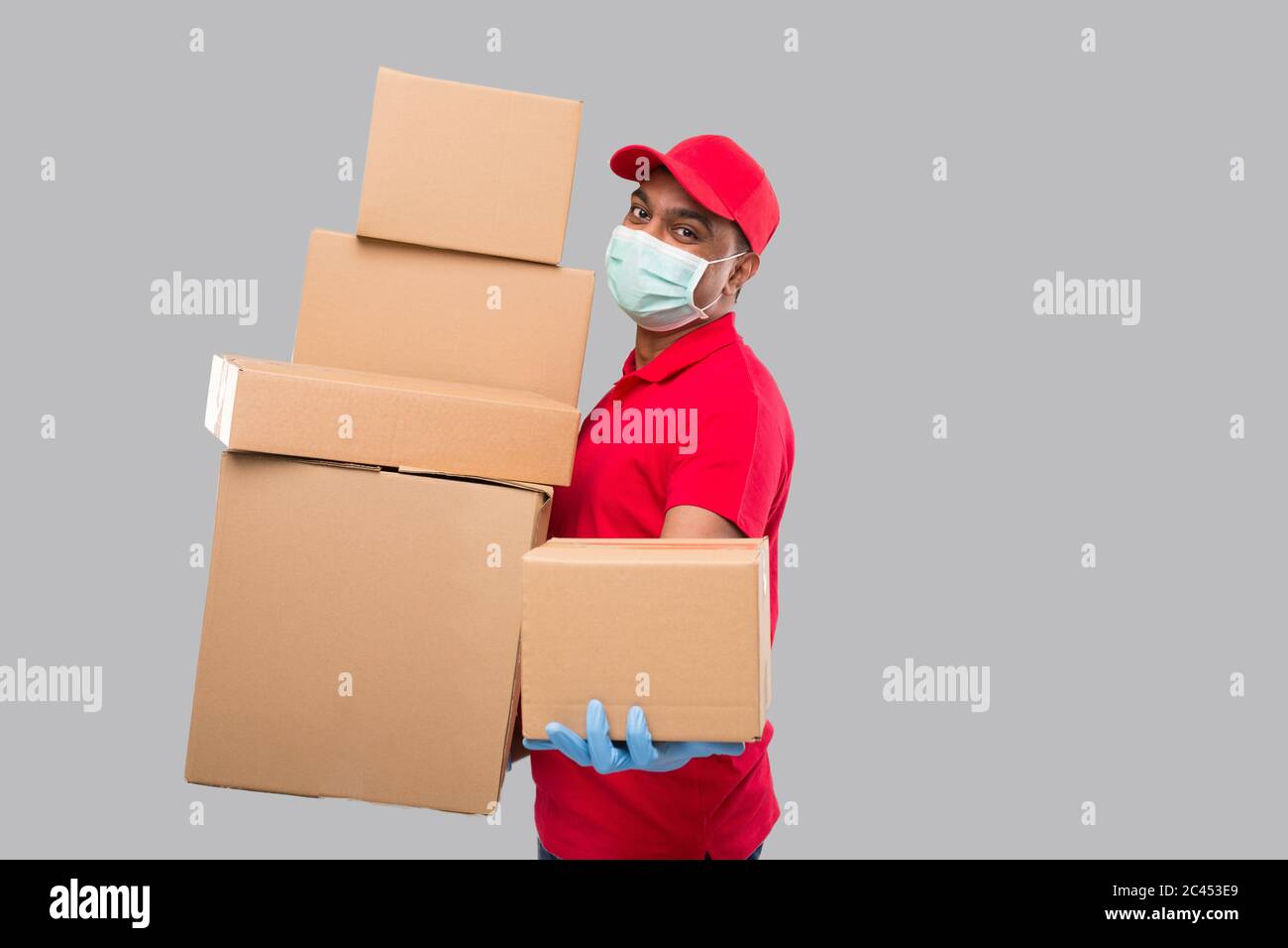 Delivery Man Holding Cardboard Boxes In Rubber Gloves Isolated