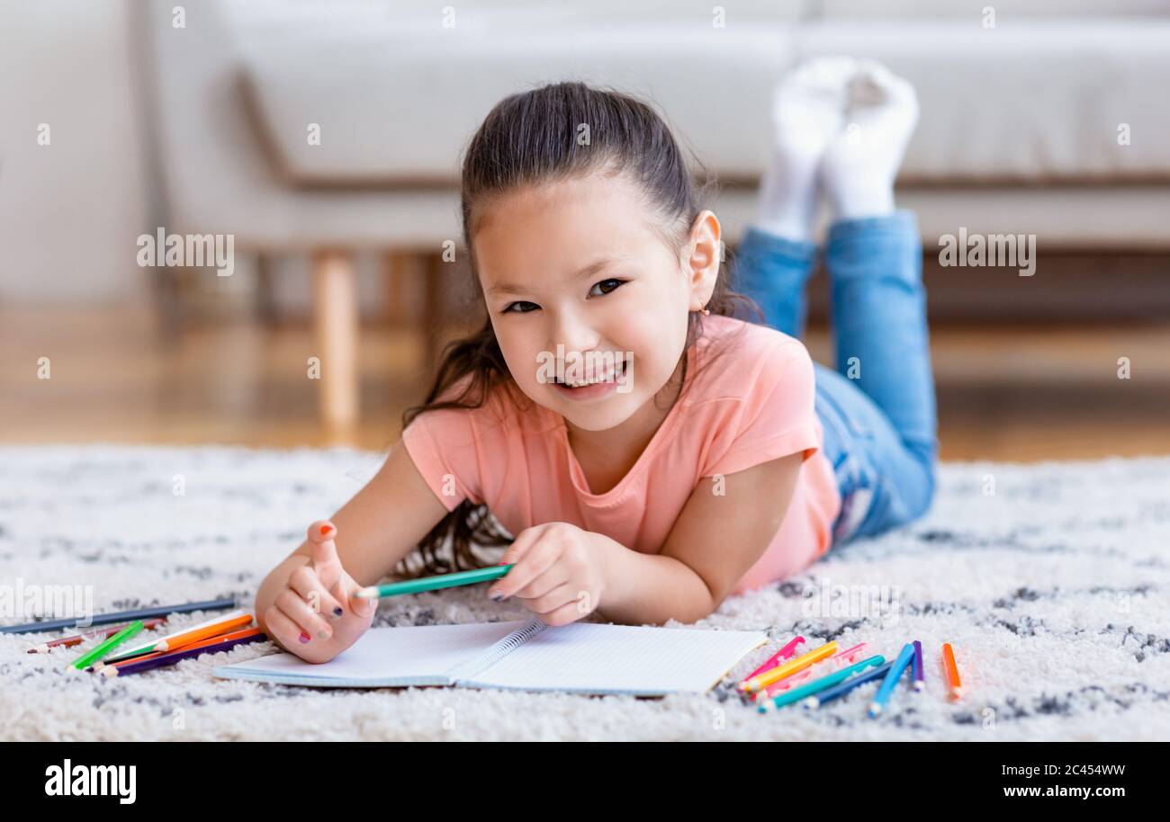 Cute Little Girl Drawing Lying On Floor At Home Stock Photo - Alamy