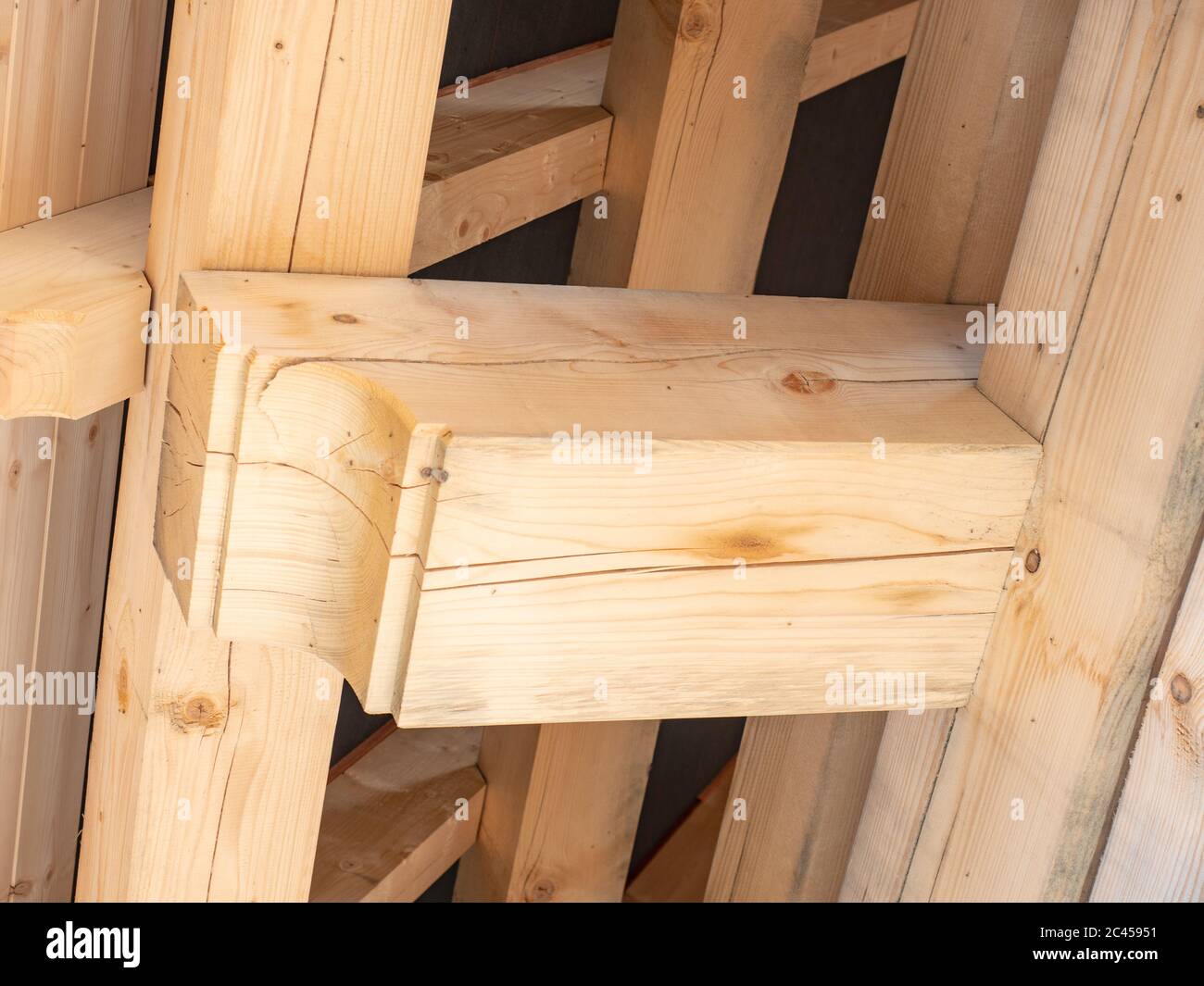 Roofing construction with wooden beams, low angle view. Big spruce logs, rafters, trusses. Stock Photo