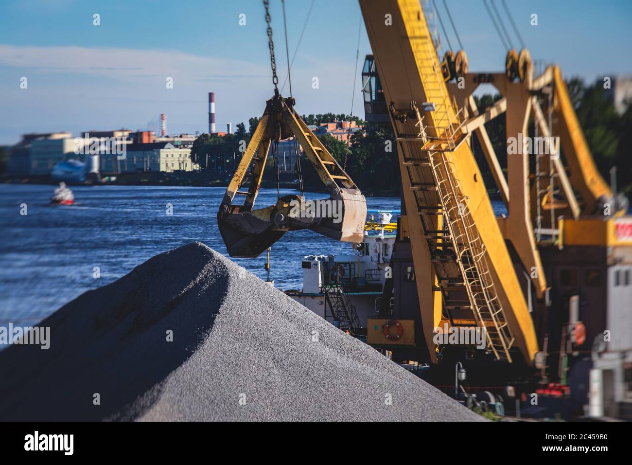 Bulk-handling crane unloading sand, road metal and gravel from cargo ...