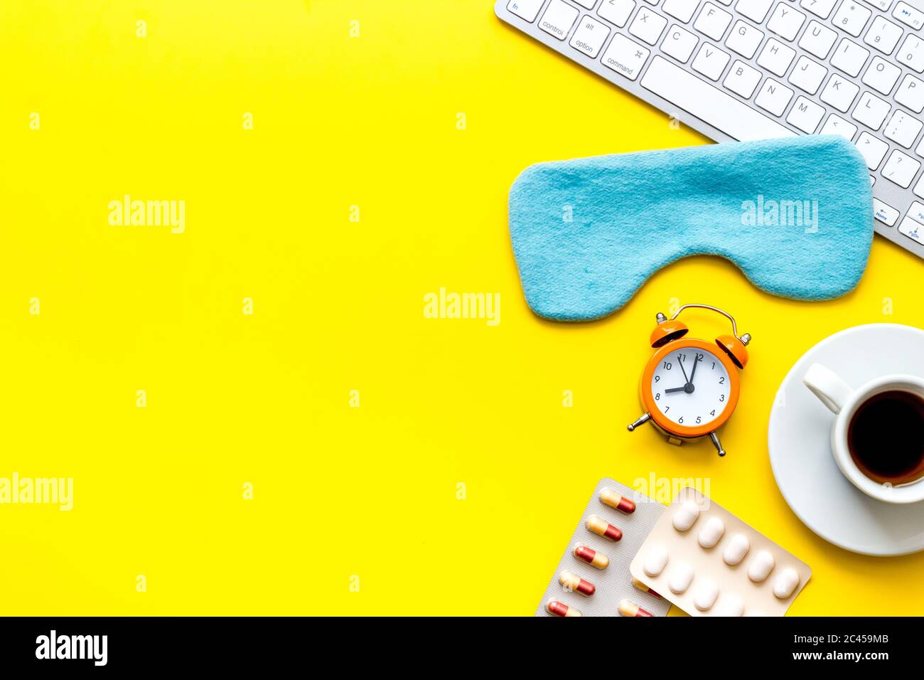 Hard exhausing work. Sleep mask on yellow office desk top-down copy space Stock Photo