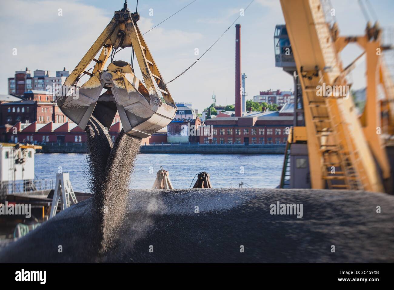 Bulk-handling crane unloading sand, road metal and gravel from cargo ...