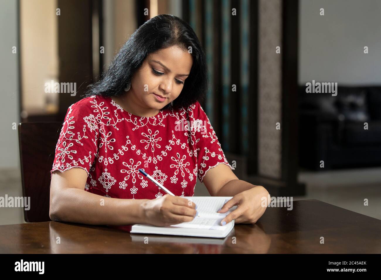 An Indian woman writing notes in her diary, asian woman sitting in her ...