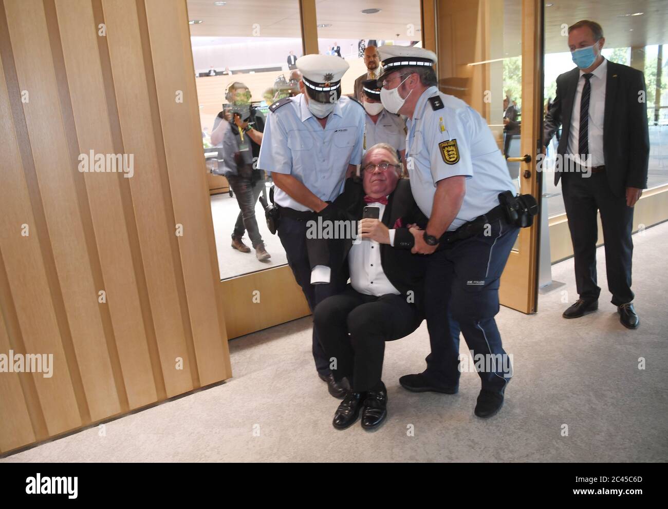 Stuttgart, Germany. 24th June, 2020. Heinrich Fiechtner (AfD, M) is  supported by police officers from the state parliament of Baden-Württemberg.  The MP was excluded from the session after a speech by Landtag