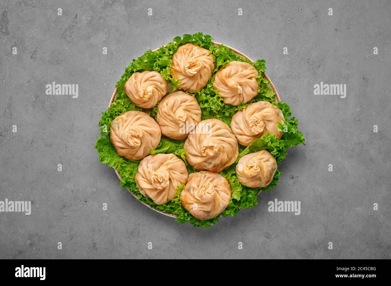 Veg Momos on gray concrete table top . Momos is the popular dish of indian, tibetan, chinese cuisines. Asian food. Vegetarian meal. Top view Stock Photo