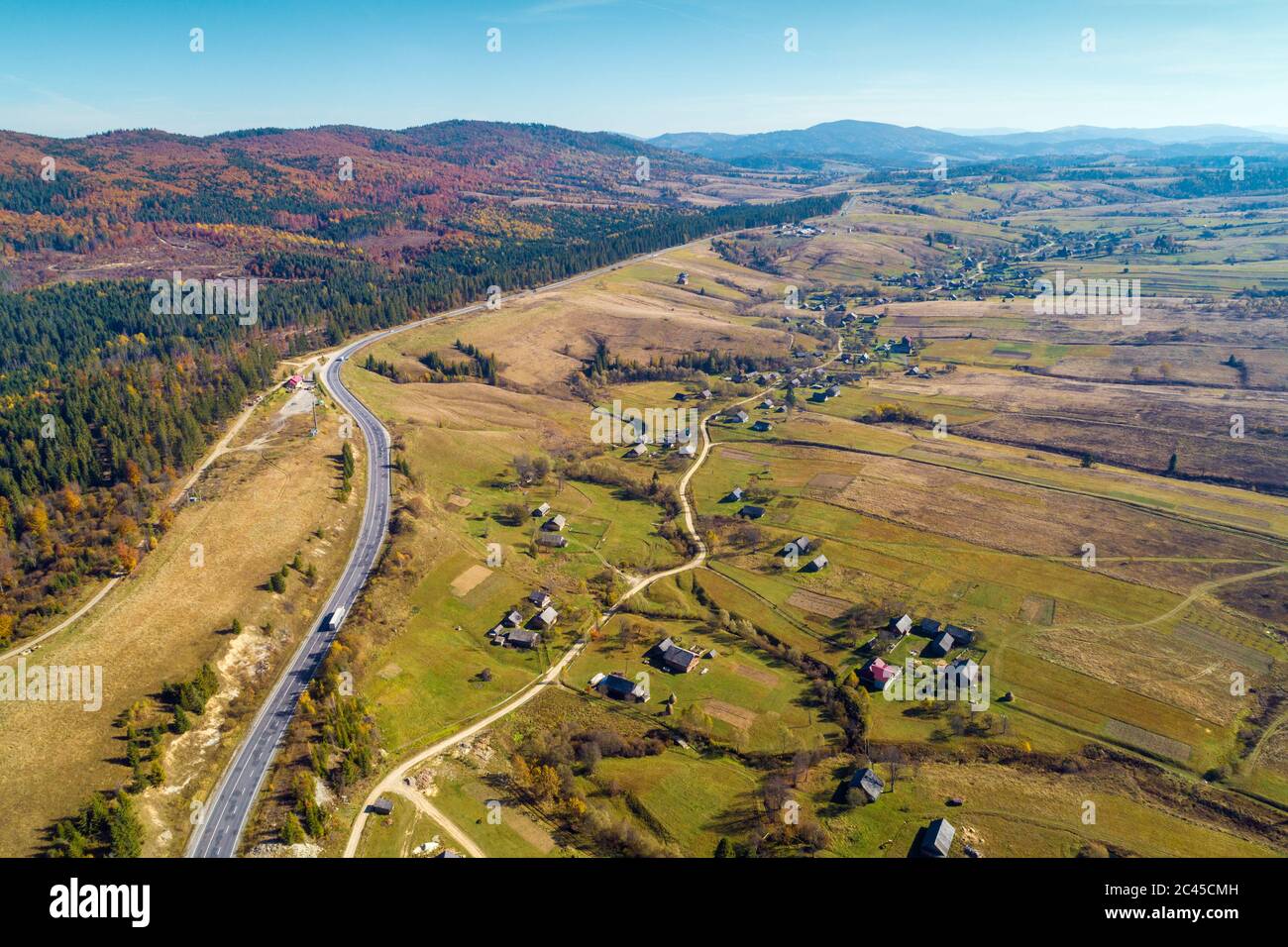 Panoramic aerial view of the mountain highway and village in spring. Beautiful skyview countryside landscape. Carpathian mountains. Ukraine Stock Photo