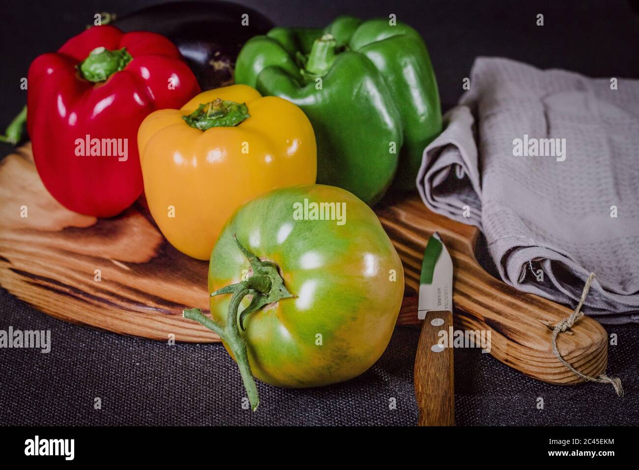 Fresh colorful peppers and eggplant on a cutting wood Stock Photo - Alamy