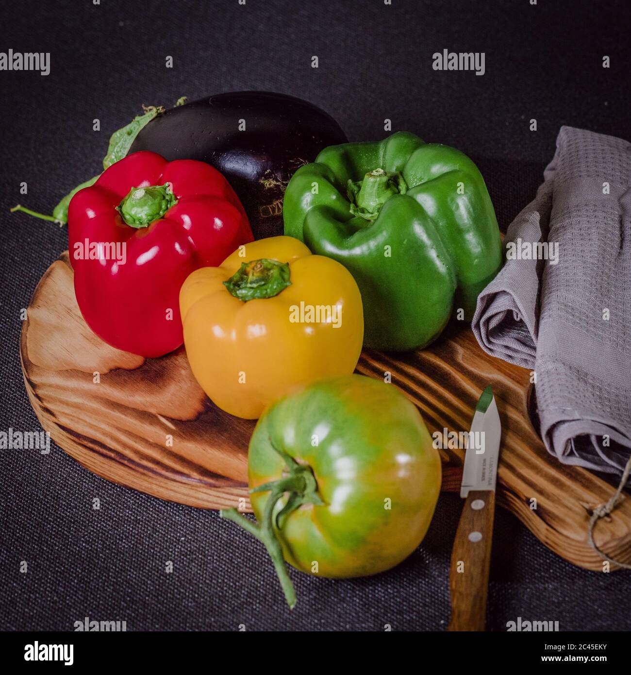 Fresh colorful peppers and eggplant on a cutting wood Stock Photo - Alamy