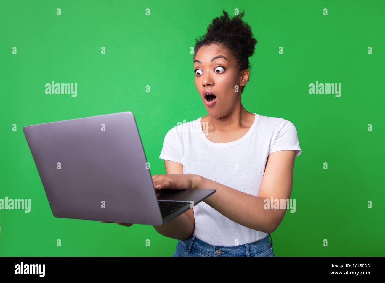 Excited black girl feeling shocked holding laptop Stock Photo