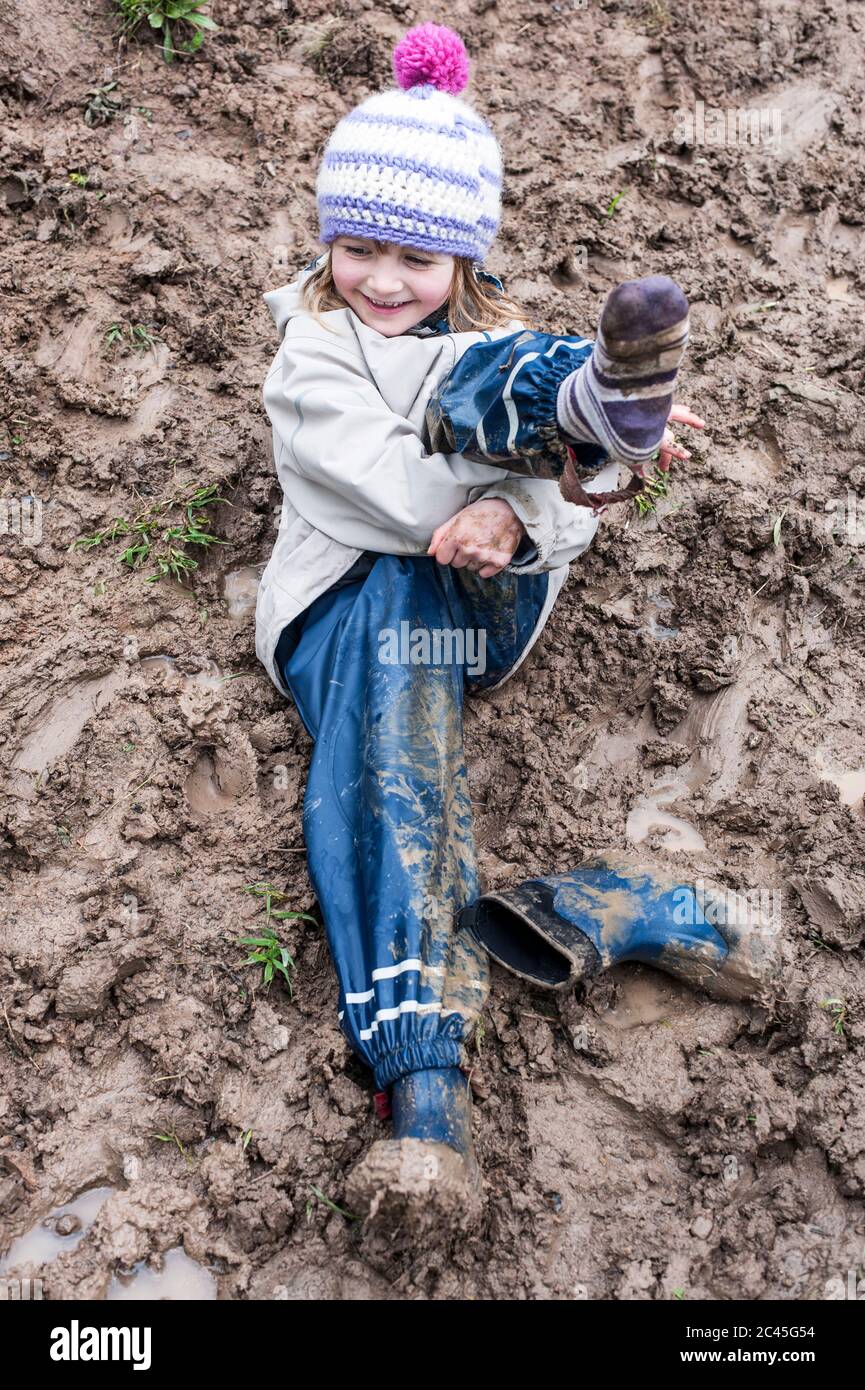 Happy girl lies in the mud Stock Photo