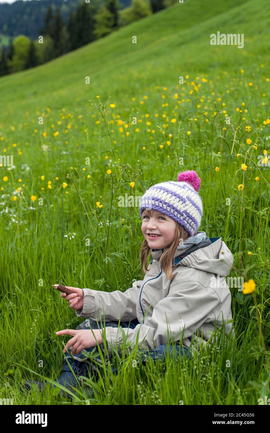 Happy girl sitting in a field hi-res stock photography and images - Alamy