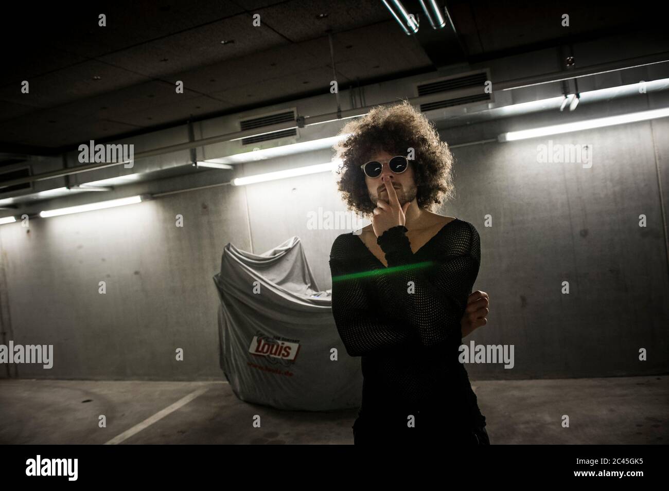 Man with curly hair in a parking garage Stock Photo