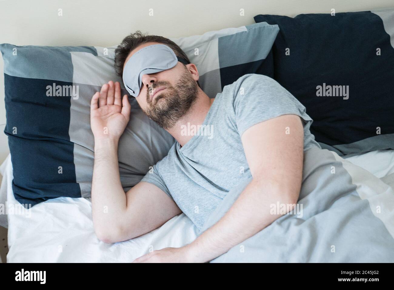 One guy sleeping and wearing an eye mask Stock Photo