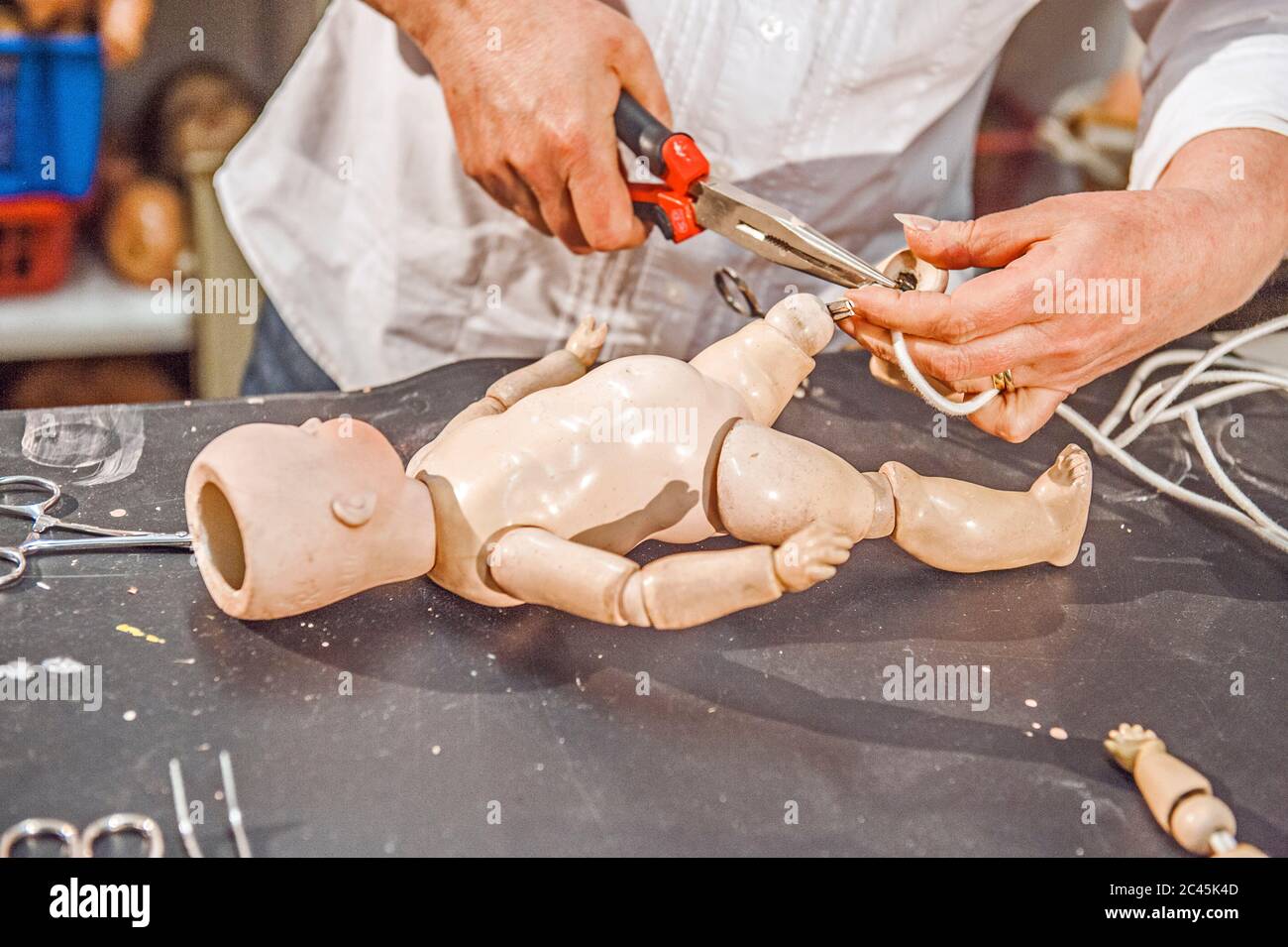 Woman works in a doll repair shop, Dresden, Saxony, Germany Stock Photo