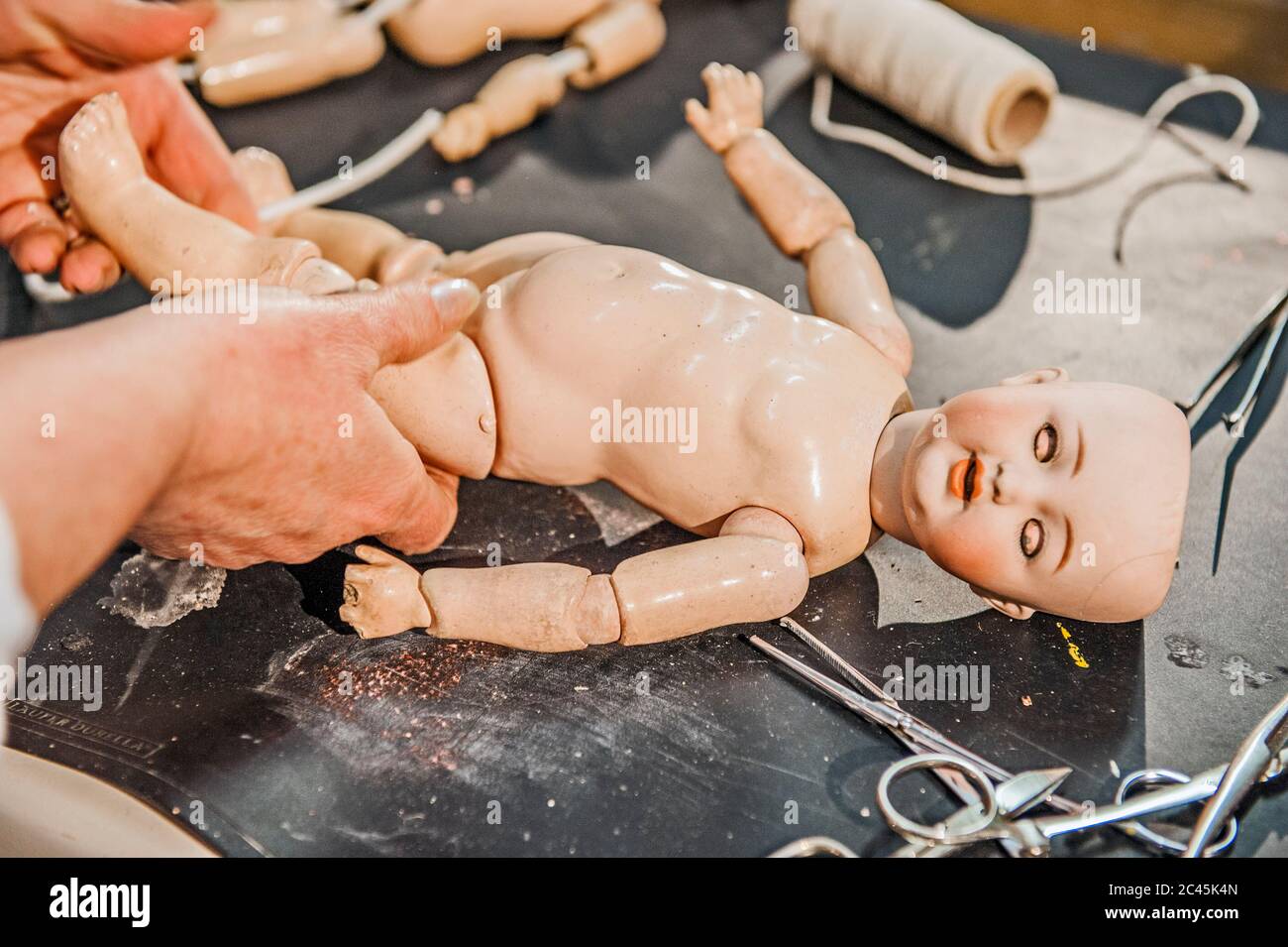 Woman works in a doll repair shop, Dresden, Saxony, Germany Stock Photo