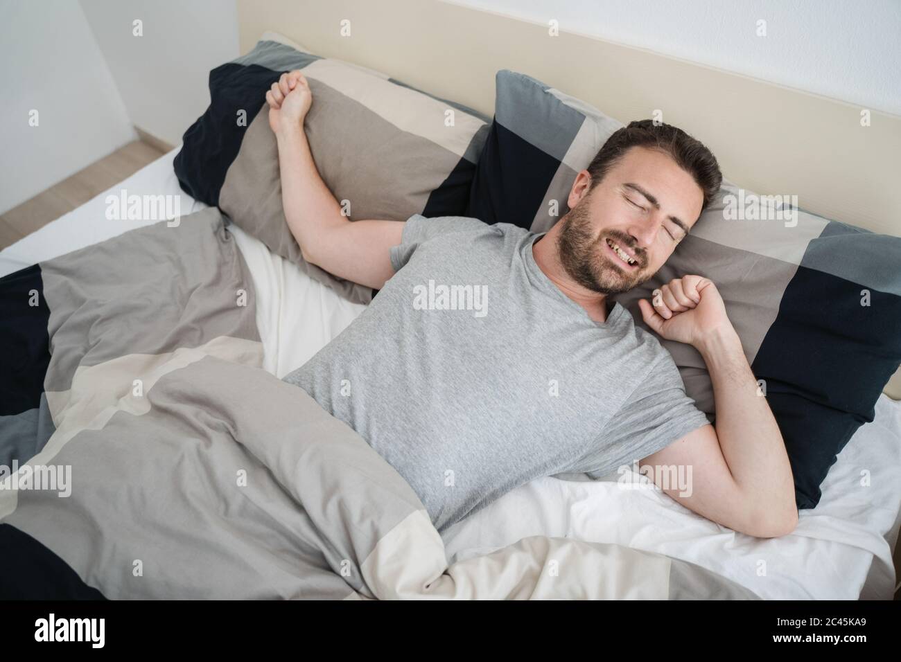 Relaxed guy napping in his bed at home Stock Photo