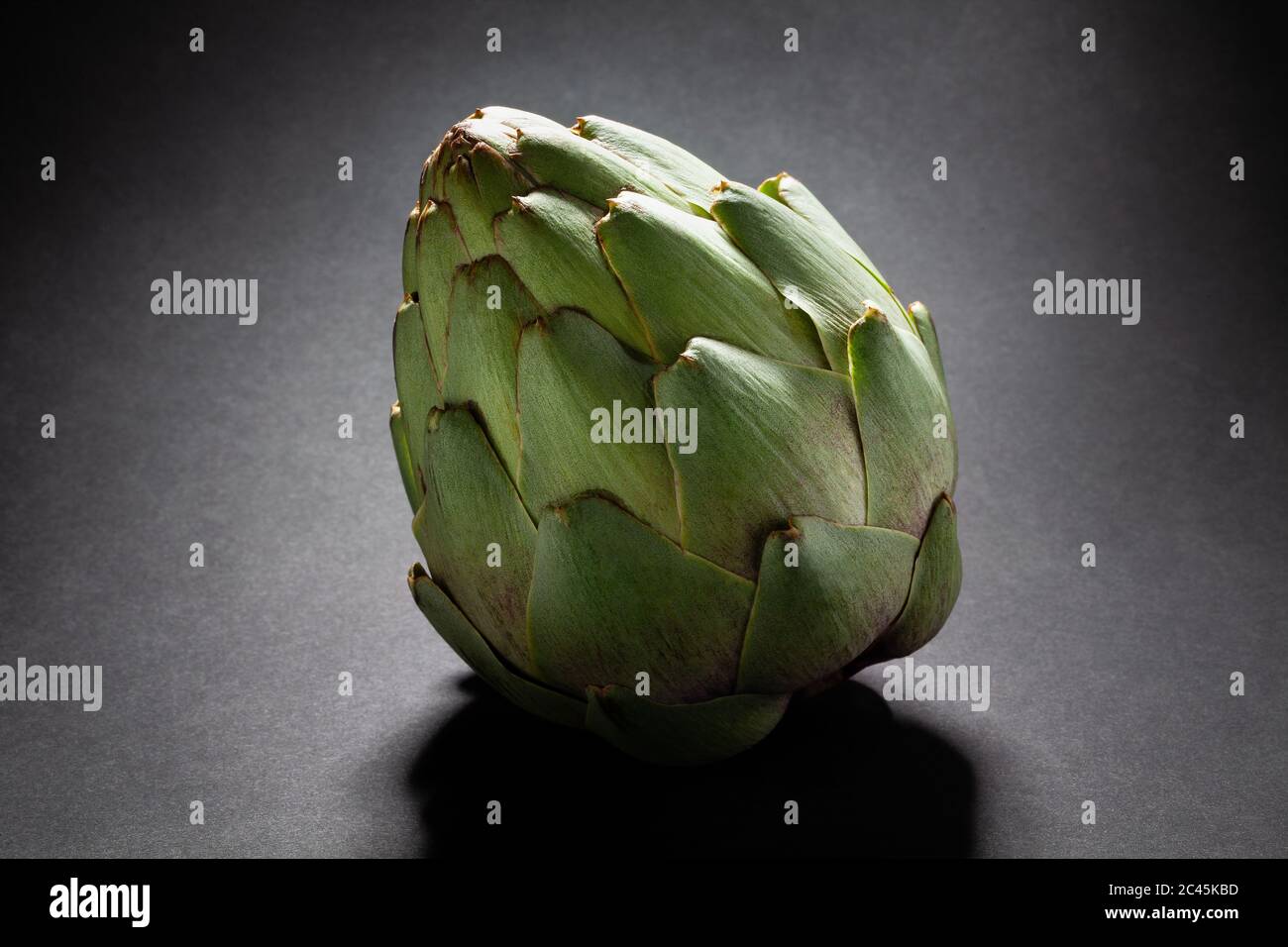 single artichoke on black background Stock Photo