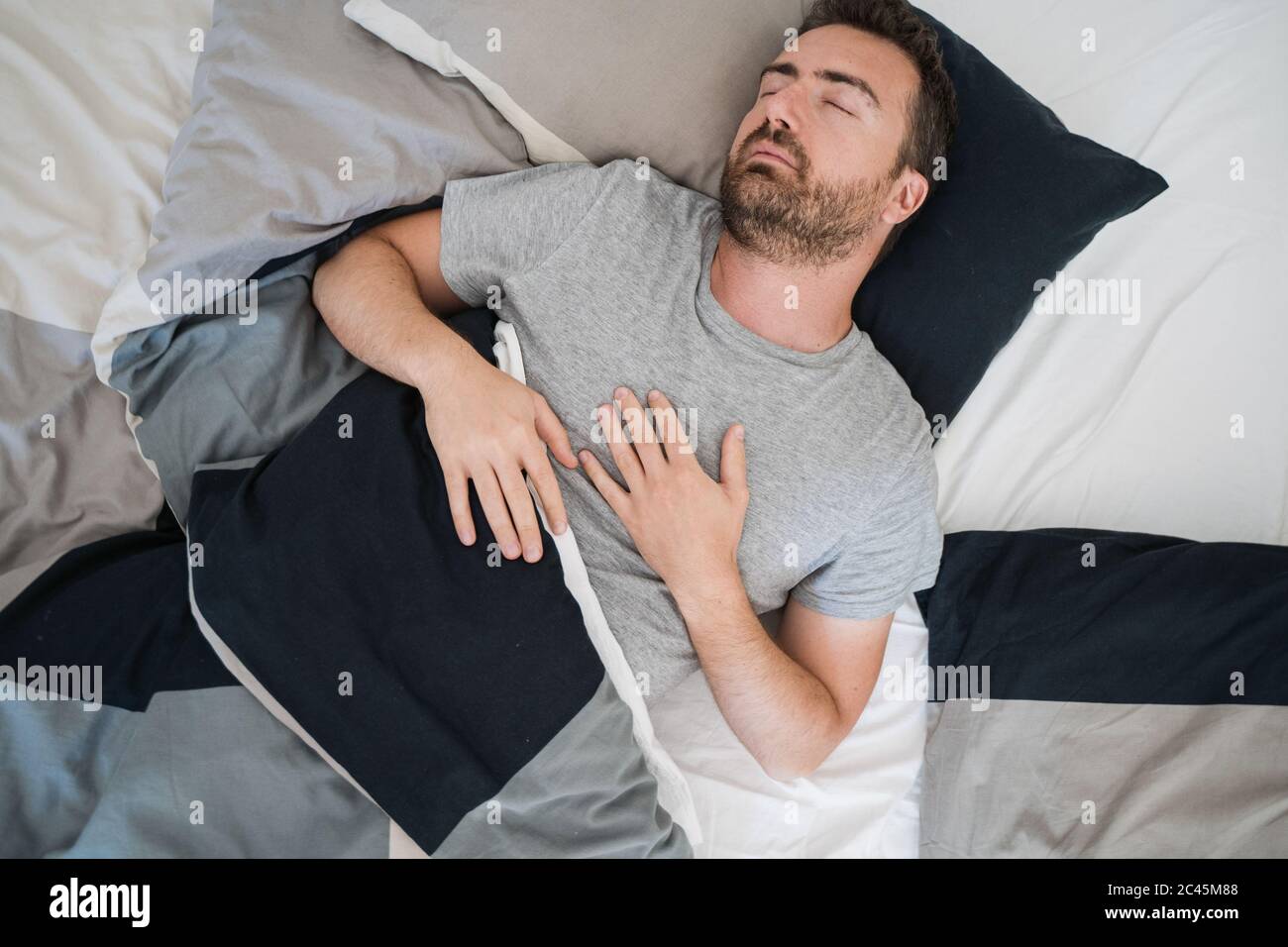 Man portrait sleeping in bed feeling comfortable Stock Photo