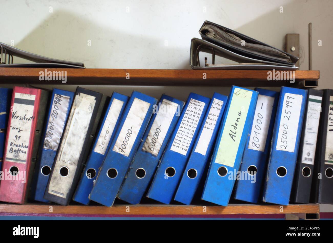 A row of folders on shelf with lettering in a wor Stock Photo