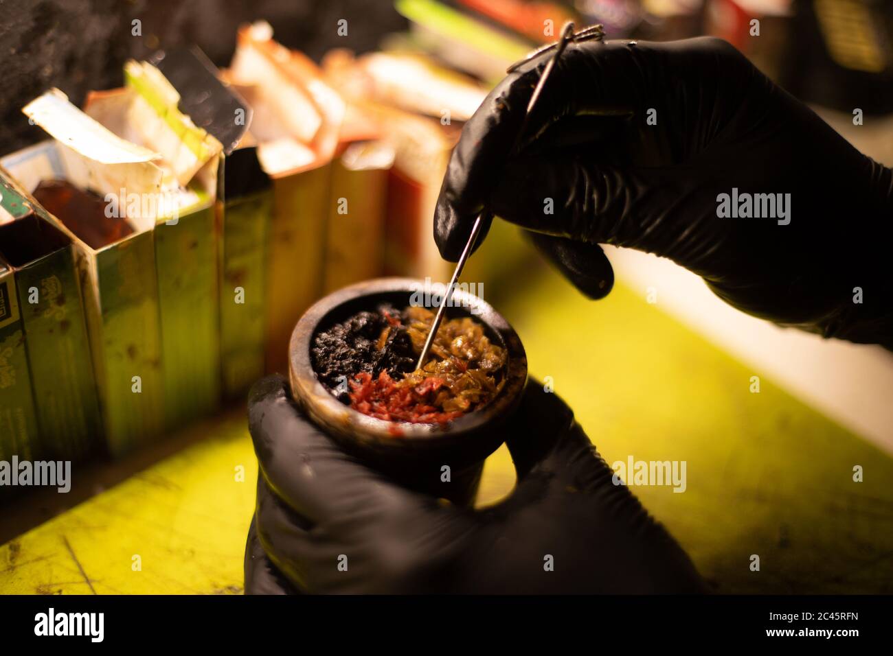 Preparation of Hookah bowl with tabacco leaf hands Stock Photo