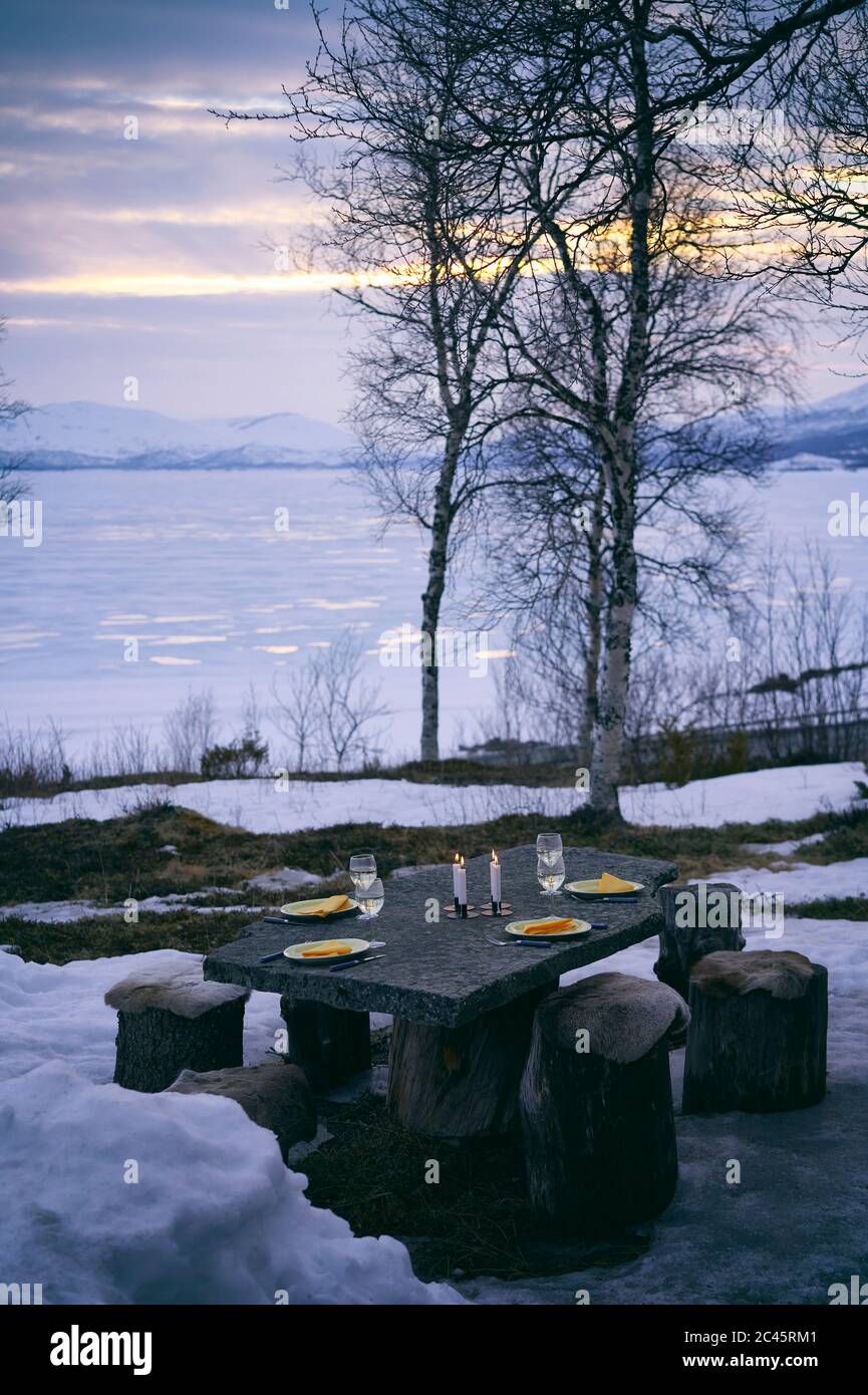 Outdoor table set with plates, wine glasses and candles in Vasterbottens Lan, Sweden. Stock Photo