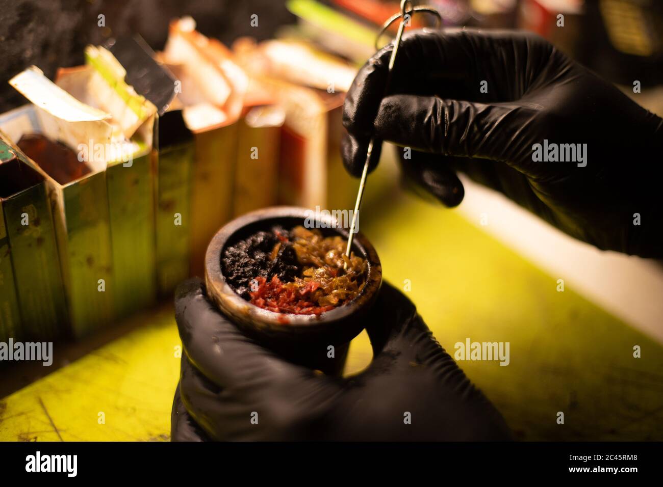 Preparation of Hookah bowl with tabacco leaf hands Stock Photo