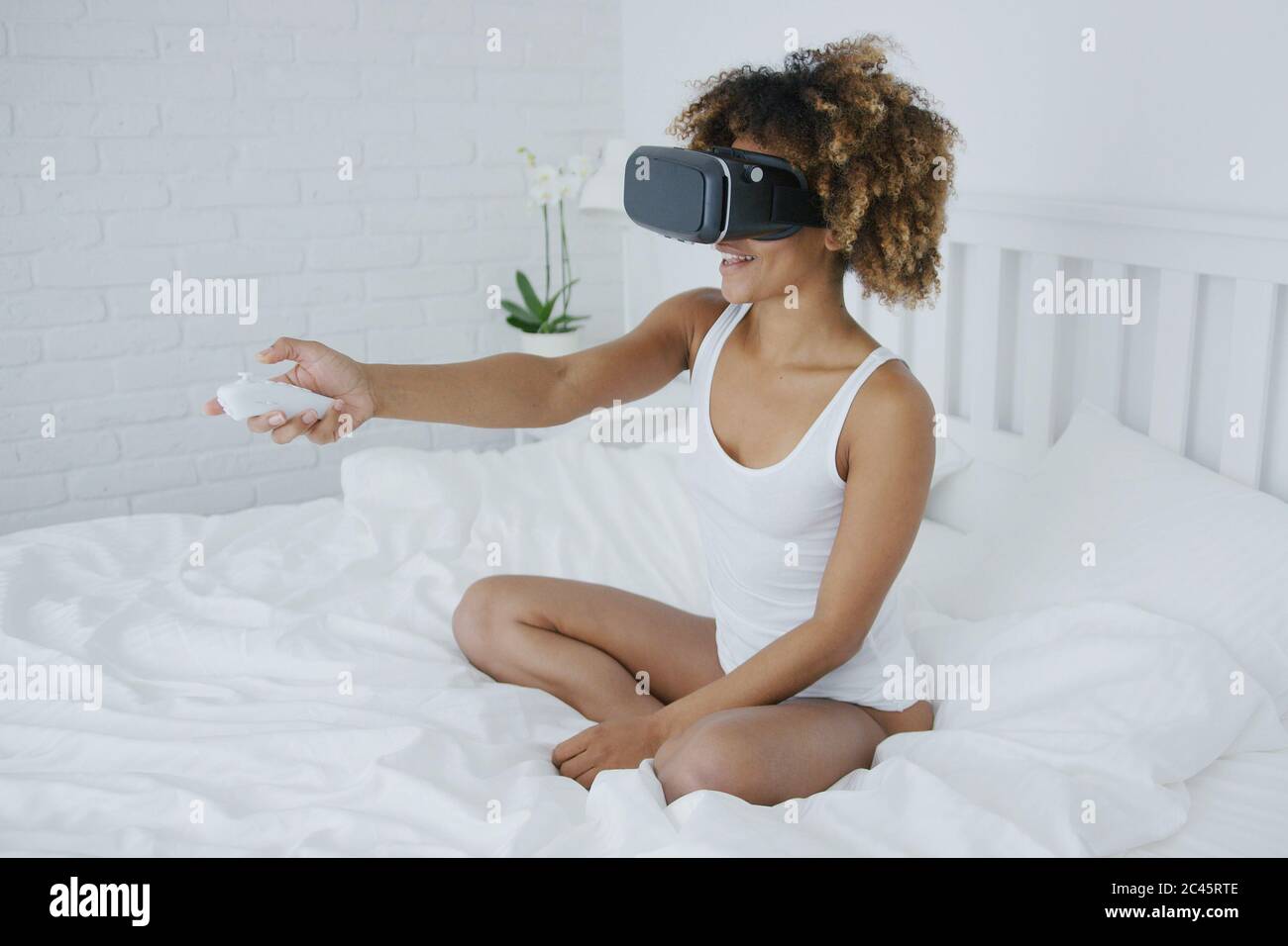 Excited woman sitting in bed hi-res stock photography and images - Alamy