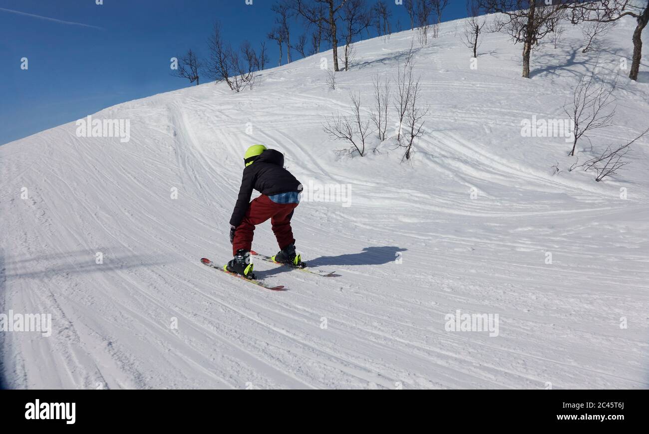 Rear view of boy skiing on a piste in Vasterbottens Lan, Sweden. Stock Photo
