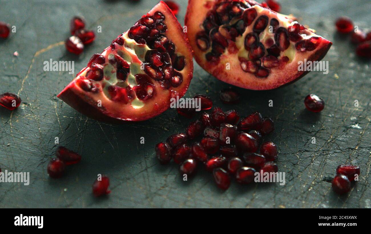 Ripe pomegranate halves on board Stock Photo