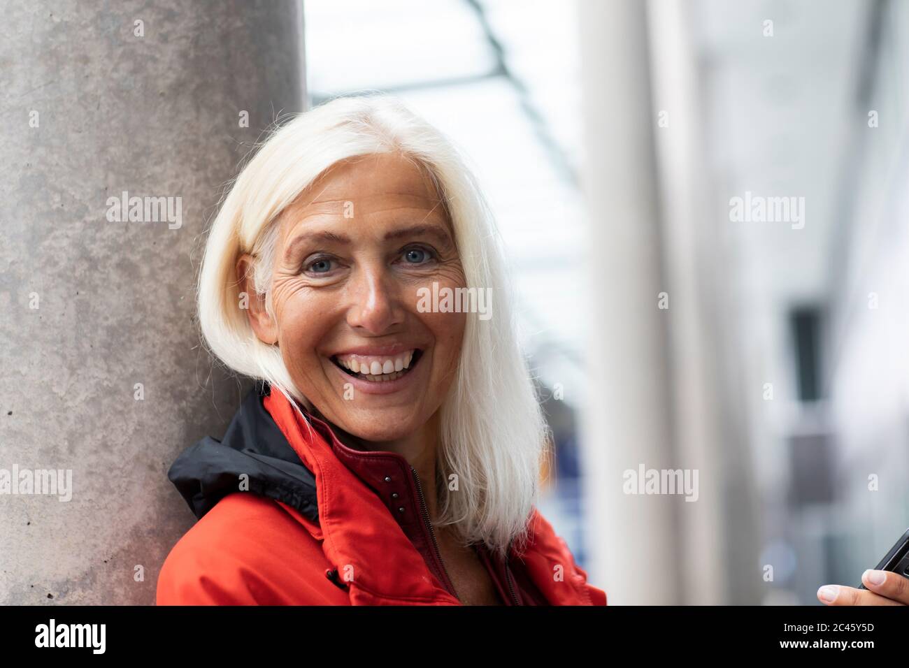 Portrait of smiling woman with long white hair, looking at camera. Stock Photo