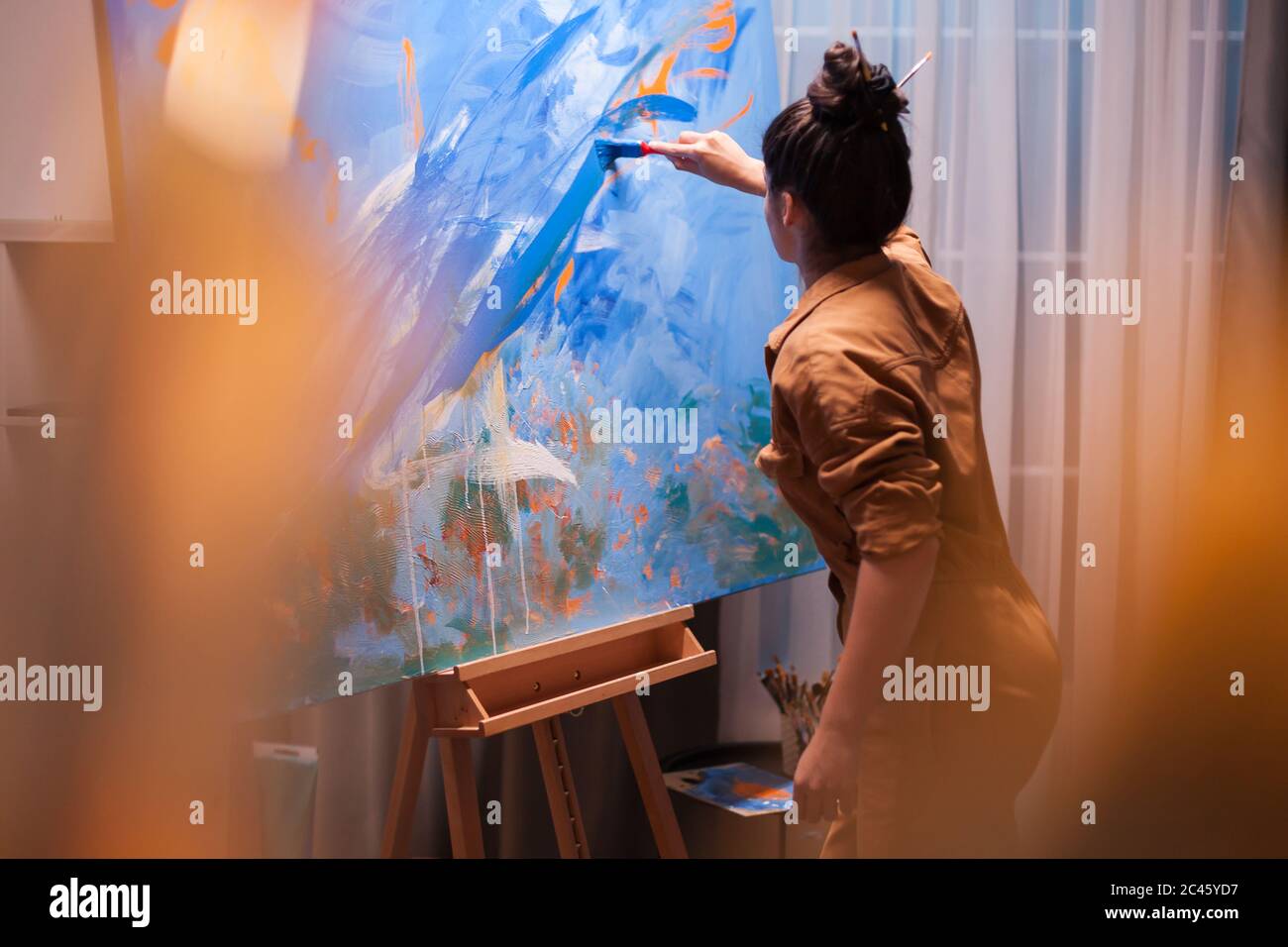 Motivated young painter making a masterpiece in art studio. Modern artwork paint on canvas, creative, contemporary and successful fine art artist drawing masterpiece Stock Photo