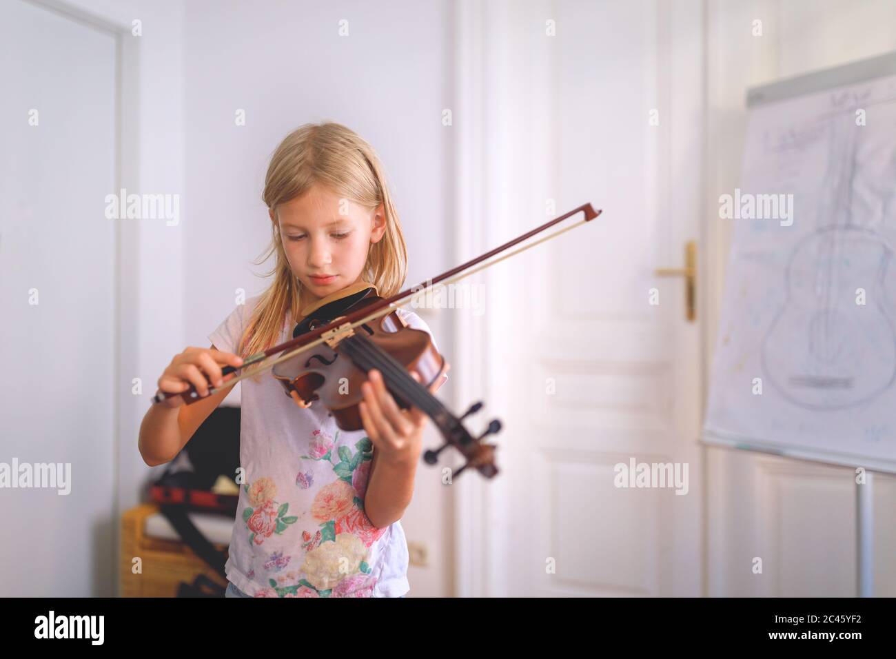 Young blond girl playing violin during violin lesson Stock Photo - Alamy